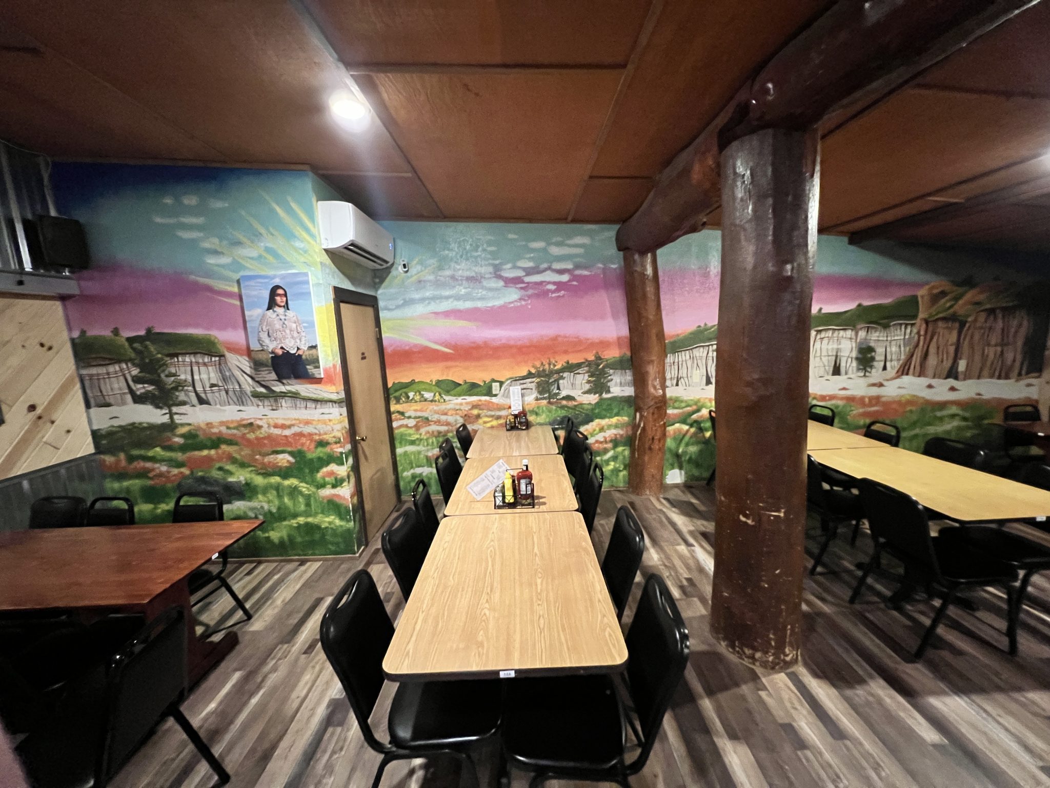 Inside Burly's: rustic brick, edison bulbs, and Rhoda's mural